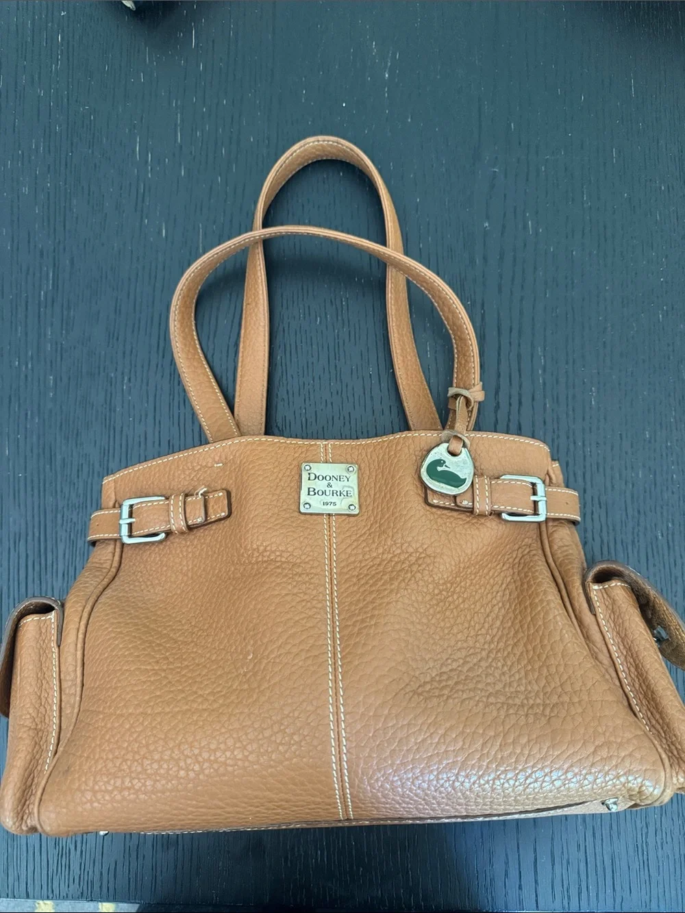 Dooney & Bourke tan pebbled leather side pockets belted satchel bag.